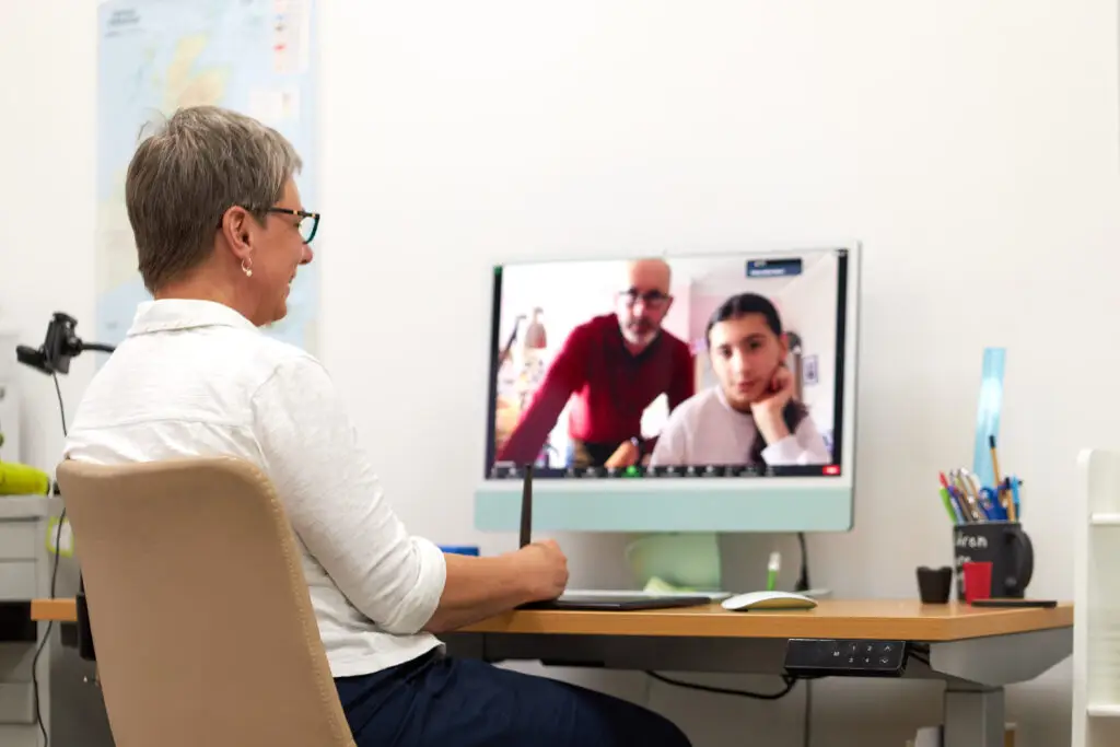 Marijke Walters delivering virtual maths tutoring on a Zoom call with female student and father